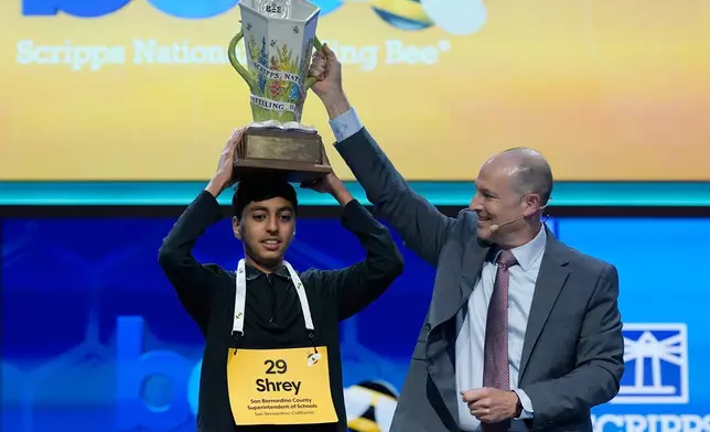 E.W. Scripps Company president and CEO Adam Symson, right, holds the trophy over winner of the 2026 Scripps National Spelling Bee, Shrey Parikh, 14, of Rancho Cucamonga, Calif., at DAR Constitution Hall, Thursday, May 28, 2026, in Washington. (AP Photo/Jose Luis Magana)
