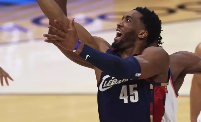 Cleveland Cavaliers guard Donovan Mitchell (45) foul by New York Knicks forward Og Anunoby during the first half of Game 3 in the Eastern Conference finals NBA basketball playoffs series Cleveland, Saturday, May 23, 2026. (AP Photo/Tim Phillis)
