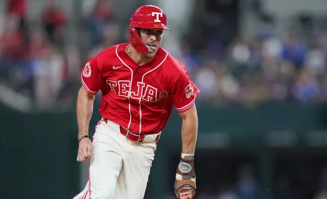 Texas Rangers' Evan Carter runs the bases while scoring from second base on a pinch hit by teammate Justin Foscue during the fifth inning of a baseball game against the Chicago Cubs, Friday, May 8, 2026, in Arlington, Texas. (AP Photo/Julio Cortez)