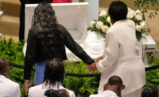 Mourners walk by caskets for the eight children who were killed during a mass shooting last month, during funeral services for the children Saturday, May 9, 2026, at the Summer Grove Baptist Church in Shreveport, La. (AP Photo/Gerald Herbert)