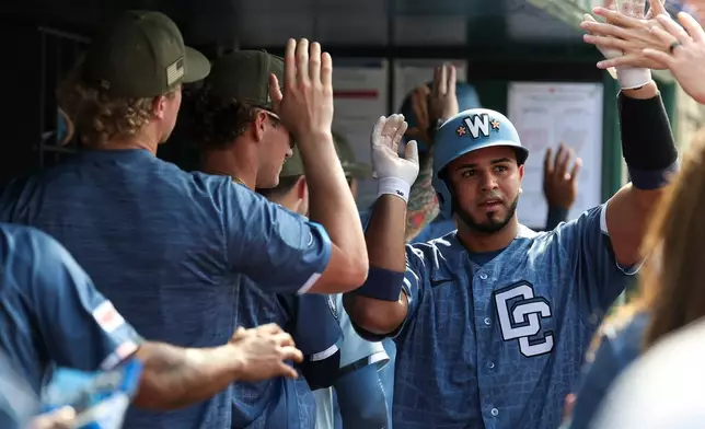 Washington Nationals' Keibert Ruiz, right, is greeted in the dugout after hitting three-run home run off Baltimore Orioles pitcher Chris Bassitt which also scored CJ Abrams and Nasim Nunez during the second inning of a baseball game, Saturday, May 16, 2026, in Washington. (AP Photo/Terrance Williams)