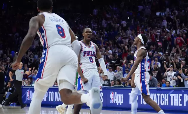 Philadelphia 76ers' Tyrese Maxey (0), Vj Edgecombe (77) and Paul George (8) celebrate during the second half of Game 6 in a first-round NBA basketball playoff series against the Boston Celtics Thursday, April 30, 2026, in Philadelphia. (AP Photo/Matt Slocum)