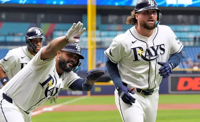 Tampa Bay Rays' Ryan Vilade, right, celebrates his three-run home run off Toronto Blue Jays pitcher Eric Lauer with Junior Caminero, center, and Chandler Simpson, left, during the first inning of a baseball game Monday, May 4, 2026, in St. Petersburg, Fla. (AP Photo/Chris O'Meara)