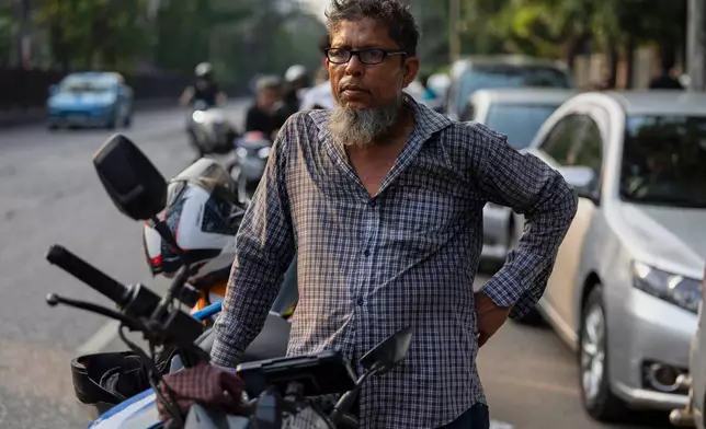 Tariqul Islam, a ride-share driver, waits in a long queue of petrol for his motorcycle in Dhaka, Bangladesh, Tuesday, April 23, 2026. (AP Photo/Abdul Goni)