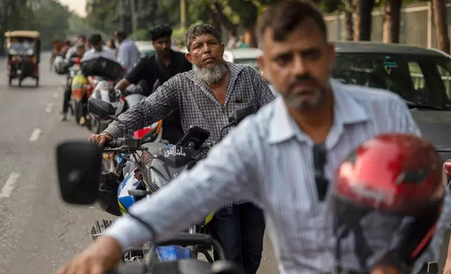 Tariqul Islam, a ride-share driver, waits in a long queue of petrol for his motorcycle in Dhaka, Bangladesh, Tuesday, April 23, 2026. (AP Photo/Abdul Goni)