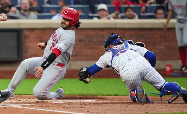 New York Mets catcher Luis Torrens, right, tags out Cincinnati Reds' Eugenio Suárez at home plate during the first inning of a baseball game Tuesday, May 26, 2026, in New York. (AP Photo/Frank Franklin II)