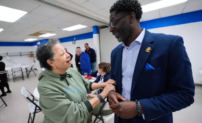 Chedrick Greene, Democratic candidate for the 35th Senate District, speaks with Juanita Foxx at a rally Monday, April 27, 2026, in Saginaw, Mich. (AP Photo/Paul Sancya)