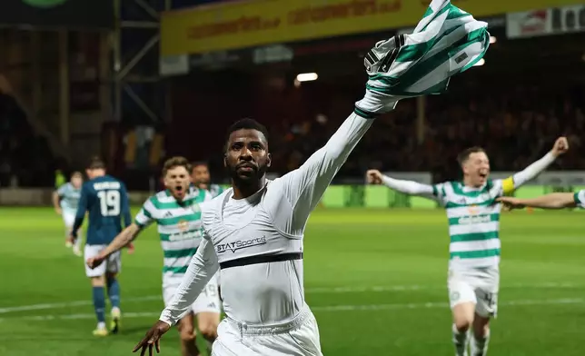 Celtic's Kelechi Iheanacho celebrates scoring their side's third goal from a penalty during the Scottish Premiership soccer match between Motherwell and Celtic, Wednesday, May 13, 2026, in Motherwell, Scotland. (Robert Perry/PA via AP)