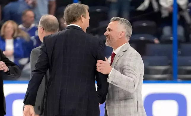 Montréal Canadiens head coach Martin St. Louis, right, congratulates Tampa Bay Lightning head coach Jon Cooper after the Canadiens defeated the Lightning in Game 7 of an NHL hockey Stanley Cup first-round playoff series, Sunday, May 3, 2026, in Tampa, Fla. (AP Photo/Chris O'Meara)