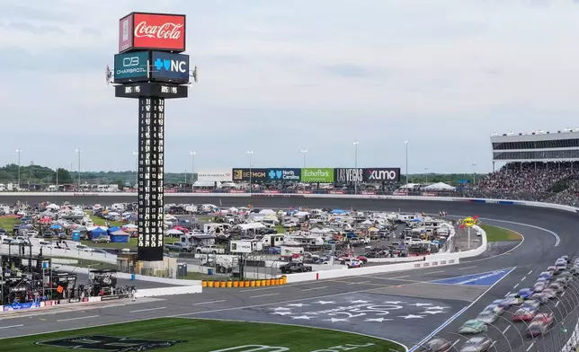 A pack of cars compete down the front stretch during a NASCAR Cup Series auto race, Sunday, May 24, 2026, in Charlotte, N.C. (AP Photo/Matt Kelley)