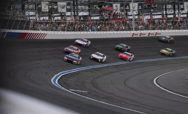 Kyle Larson (5) leads a pack of cars into Turn 4 during a NASCAR Cup Series auto race, Sunday, May 24, 2026, in Charlotte, N.C. (AP Photo/Matt Kelley)