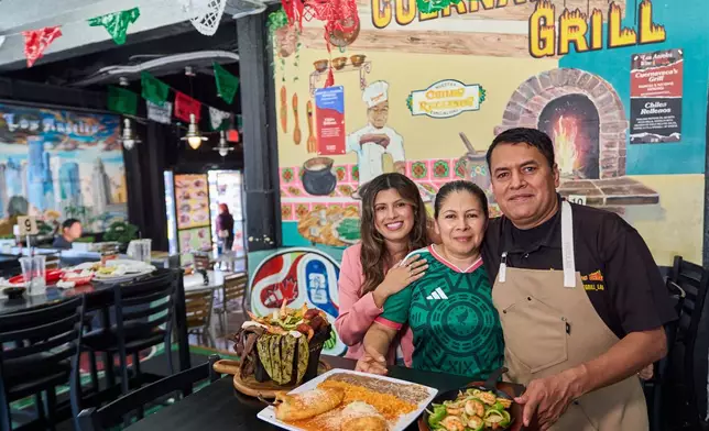 Chef Marco Mendoza, right, his wife Maria Luisa Mendoza, center, and daughter Nayomie Mendoza, pose for a picture at their Mexican restaurant Cuernavaca's Grill in downtown Los Angeles, Tuesday, April 28, 2026. (AP Photo/Damian Dovarganes)