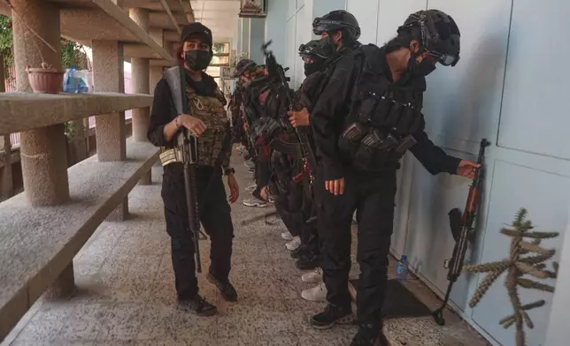 Security forces stand guard outside a polling station during follow-up parliamentary elections in Hassakeh, northeastern Syria, Sunday, May 24, 2026. (AP Photo/Baderkhan Ahmad)
