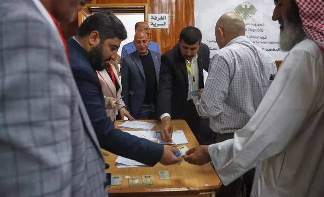 Election officials verify voters' identification documents during follow-up parliamentary elections in Hassakeh, northeastern Syria, Sunday, May 24, 2026. (AP Photo/Baderkhan Ahmad)