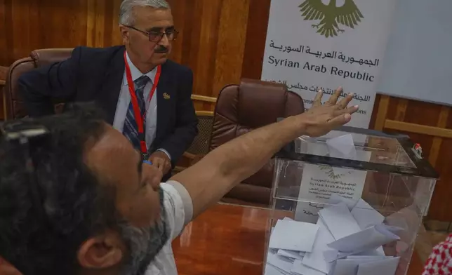 A voter casts a ballot during follow-up parliamentary elections in Hassakeh, northeastern Syria, Sunday, May 24, 2026. (AP Photo/Baderkhan Ahmad)
