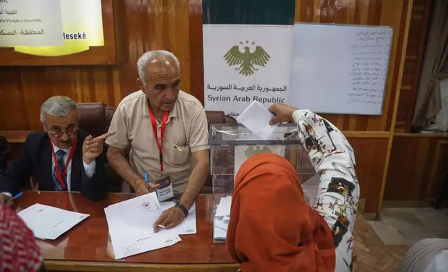 A voter casts a ballot during follow-up parliamentary elections in Hassakeh, northeastern Syria, Sunday, May 24, 2026. (AP Photo/Baderkhan Ahmad)