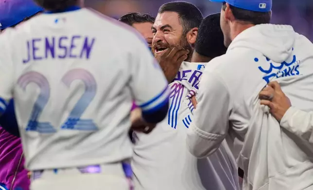 Kansas City Royals players celebrate after Kyle Isbel, center, hit a single to drive in the game-winning run during the ninth inning of a baseball game against the Detroit Tigers, Friday, May 8, 2026, in Kansas City, Mo. (AP Photo/Charlie Riedel)