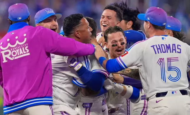 Kansas City Royals players celebrate after Kyle Isbel hit a single to drive in the game-winning run during the ninth inning of a baseball game against the Detroit Tigers, Friday, May 8, 2026, in Kansas City, Mo. (AP Photo/Charlie Riedel)