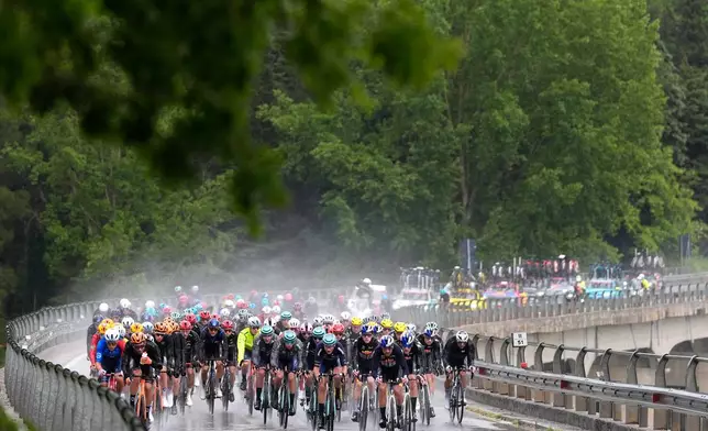 The pack of riders pedals under pouring rain, during the fifth stage of the Giro d'Italia cycling race, from Praia a Mare to Potenza, Italy, Wednesday, May 13, 2026. (Fabio Ferrari/LaPresse via AP)