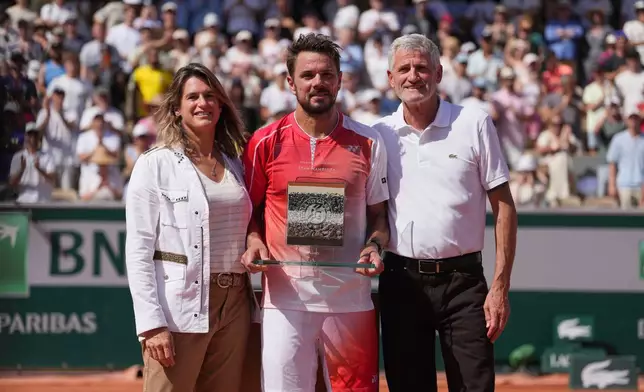 From left: Roland Garros tournament director and former tennis star Amelie Mauresmo, Stan Wawrinka of Switzerland and French tennis federation President Gilles Moretton pose for a picture after the first round men's singles tennis match between Stan Wawrinka of Switzerland and Jesper De Jong of the Netherlands at the French Open tennis tournament in Paris, Monday, May 25, 2026. (AP Photo/Thibault Camus)