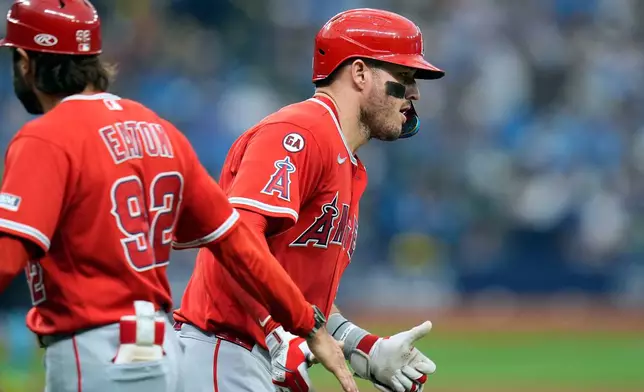 Los Angeles Angels' Mike Trout celebrates his solo home run off Tampa Bay Rays pitcher Casey Legumina with first base coach Adam Eaton (92) during the fifth inning of a baseball game Saturday, May 30, 2026, in St. Petersburg, Fla. (AP Photo/Chris O'Meara)