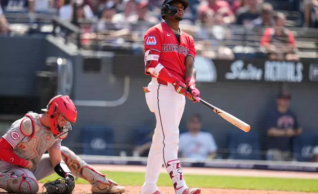 Cleveland Guardians' Angel Martínez watches his home run in front of Cincinnati Reds catcher Tyler Stephenson, left, in the seventh inning of a baseball game against the Cincinnati Reds in Cleveland, Sunday, May 17, 2026. (AP Photo/Sue Ogrocki)