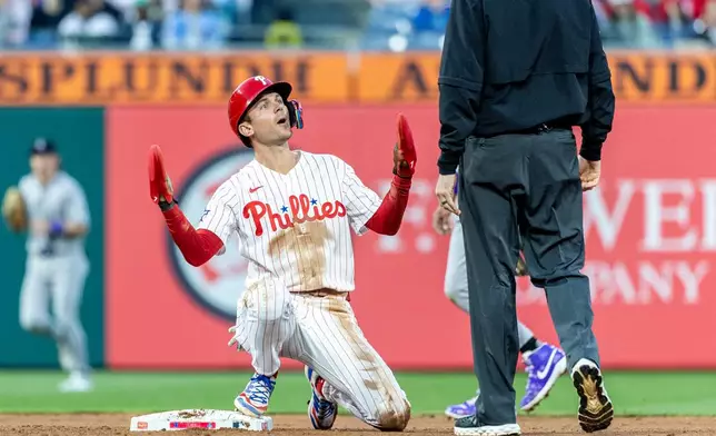 Philadelphia Phillies' Trea Turner, left, reacts to the call by umpire Nic Lentz after being called out at second base in the fourth inning of a baseball game against the Colorado Rockies, Saturday, May 9, 2026, in Philadelphia. (AP Photo/Laurence Kesterson)
