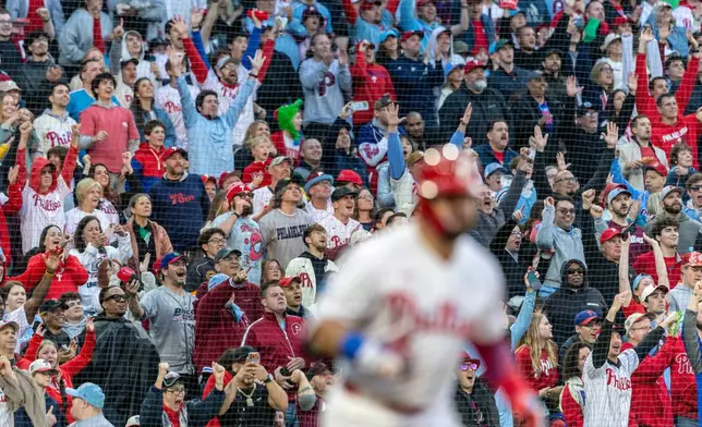 Fans react after Philadelphia Phillies' Kyle Schwarber hit a three-run home runin the third inning of a baseball game against the Colorado Rockies, Saturday, May 9, 2026, in Philadelphia. (AP Photo/Laurence Kesterson)