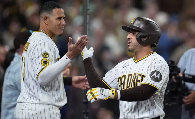 San Diego Padres' Ramón Laureano, right, celebrates with teamate Manny Machado after hitting a home run during the eighth inning of a baseball game against the Philadelphia Phillies Tuesday, May 26, 2026, in San Diego. (AP Photo/Gregory Bull)