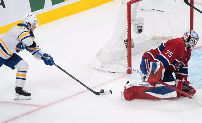 Buffalo Sabres' Zach Benson, left, scores against Montreal Canadiens goaltender Jakub Dobes (75) during the second period of Game 6 in a second-round NHL hockey Stanley Cup playoff series in Montreal, Saturday, May 16, 2026. (Christinne Muschi/The Canadian Press via AP)
