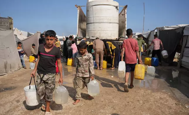 Displaced Palestinians gather to collect water from a truck at a makeshift tent camp in Khan Younis, southern Gaza Strip, Thursday, April 30, 2026. (AP Photo/Abdel Kareem Hana)