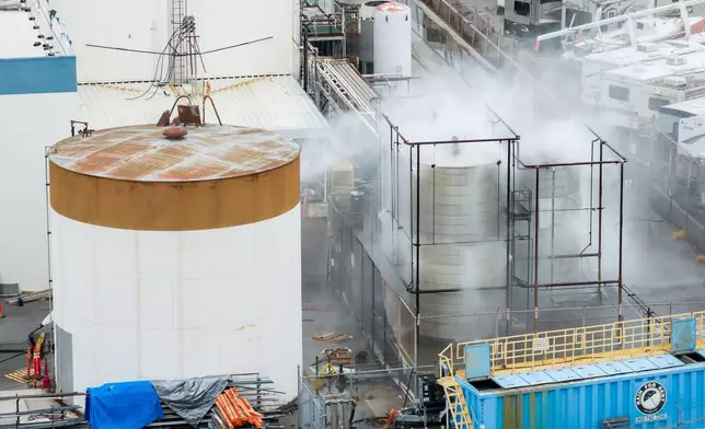 Water is sprayed on a damaged tank at GKN Aerospace in Garden Grove, Calif., on Sunday, May 24, 2026, after the tank containing a chemical used to make plastic parts overheated Thursday. (AP Photo/Ethan Swope)