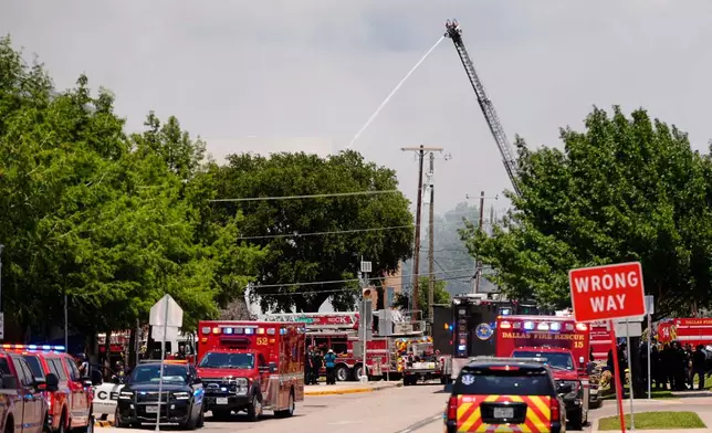 Police and firefighting crews respond to the scene of a large fire at an apartment complex in Dallas, Thursday, May 28, 2026. (AP Photo/Gabriela Passos)
