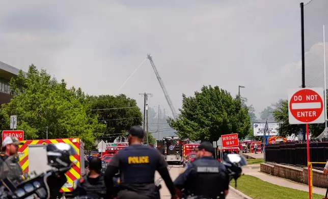 Police and firefighting crews respond to the scene of a large fire at an apartment complex in Dallas, Thursday, May 28, 2026. (AP Photo/Gabriela Passos)