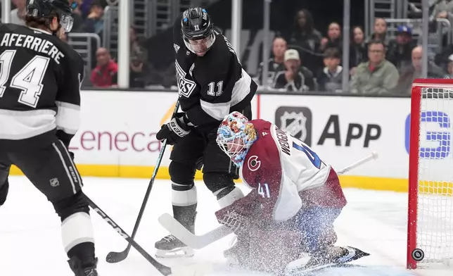 Los Angeles Kings' Anze Kopitar (11) watches a shot by Joel Edmundson get past Colorado Avalanche goaltender Scott Wedgewood for goal during the second period of Game 4 in the first round of an NHL hockey Stanley Cup playoff series Sunday, April 26, 2026, in Los Angeles. (AP Photo/Scott Strazzante)
