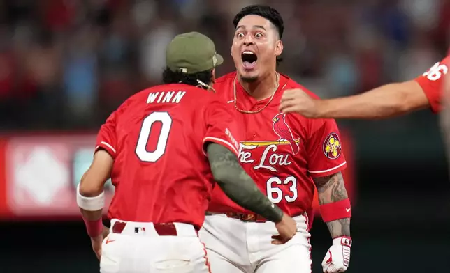 St. Louis Cardinals' Yohel Pozo (63) is congratulated by teammate Masyn Winn (0) after hitting a walk-off single to defeat the Kansas City Royals during the 11th inning of a baseball game Friday, May 15, 2026, in St. Louis. (AP Photo/Jeff Roberson)