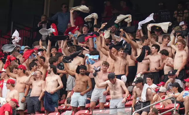 Fans cheer and wave their shirts above their heads during the fourth inning of a baseball game between the St. Louis Cardinals and the Kansas City Royals Saturday, May 16, 2026, in St. Louis. (AP Photo/Jeff Roberson)