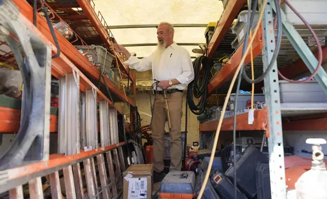 Matthew Haines, owner of the Oakwood Apartments, collects tools from the back of his work truck as he performs maintanence at the comminty housing location in Arlington, Texas, Tuesday, March 17, 2026. (AP Photo/Tony Gutierrez)