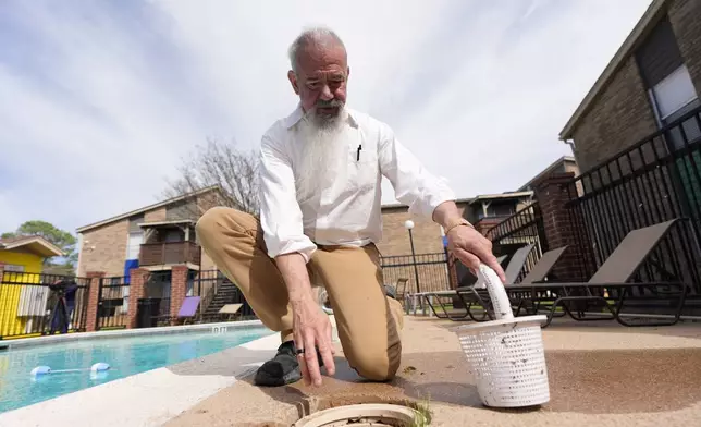 Matthew Haines, owner of the Oakwood Apartments, performs pool maintanence at the comminty housing location in Arlington, Texas, Tuesday, March 17, 2026. (AP Photo/Tony Gutierrez)