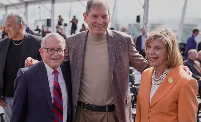 Ohio Gov. Mike DeWine, left, and his wife, Frances Struewing, right, pose for a photo with former Cleveland Browns quarterback Bernie Kosar, center, before groundbreaking ceremonies for the new Browns stadium in Brook Park, Ohio, Thursday, April 30, 2026. (AP Photo/Sue Ogrocki)