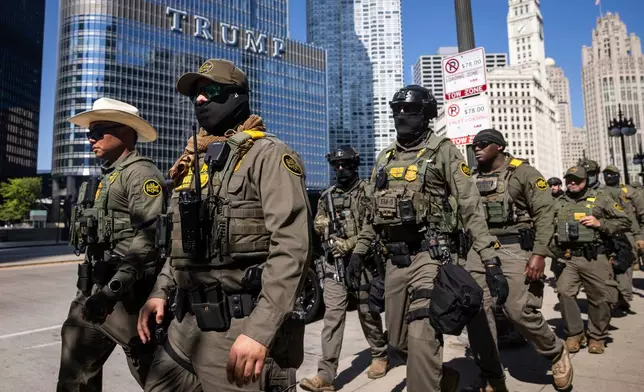 Federal agents from U.S. Immigration and Customs Enforcement and U.S. Customs and Border Protection walk along West Wacker Drive in the Loop, Sunday, Sept. 28, 2025, in Chicago. (Ashlee Rezin/Chicago Sun-Times via AP)