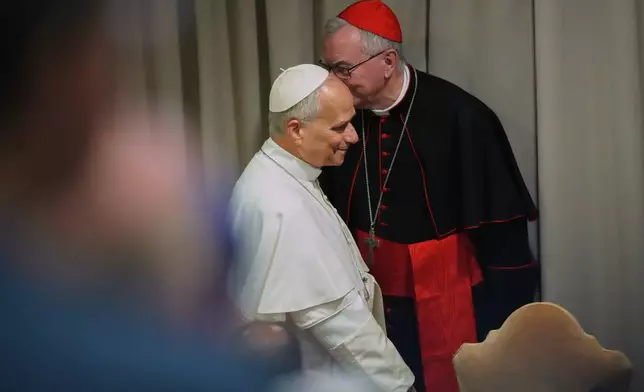 Pope Leo XIV, left, arrives with Vatican Secretary of State Cardinal Pietro Parolin for the presentation of his first encyclical, "Magnifica humanitas: On Safeguarding the Human Person in the Time of Artificial Intelligence," at the Vatican, Monday, May 25, 2026. (AP Photo/Alessandra Tarantino)
