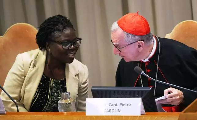Vatican Secretary of State Cardinal Pietro Parolin, right, talks to theologian Leocadie Lushombo during the presentation of his first encyclical, "Magnifica humanitas: On Safeguarding the Human Person in the Time of Artificial Intelligence," at the Vatican, Monday, May 25, 2026. (AP Photo/Alessandra Tarantino)
