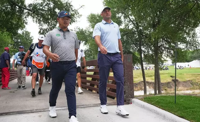 Scottie Scheffler, right, and Si Woo Kim, of South Korea, cross a bridge between holes during the first round of the Byron Nelson golf tournament in McKinney, Texas, Thursday, May 21, 2026. (AP Photo/LM Otero)932944