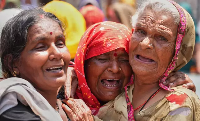 Relatives cry after seeing the body of Summit Yadav, 24, who died after a wall of his neighbor's house collapsed following dust storms and heavy rain in Prayagraj, India, Thursday, May 14, 2026. (AP Photo/Rajesh Kumar Singh)