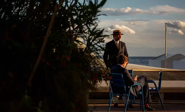 Men relax at sunset on the Boulevard de la Croisette during the 79th international film festival, Cannes, southern France, Thursday, May 14, 2026. (AP Photo/Andreea Alexandru)