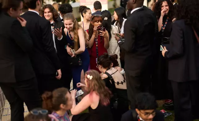 Festivalgoers get ready as they wait in line before the 79th international film festival, Cannes, southern France, Sunday, May 17, 2026. (AP Photo/John Locher)