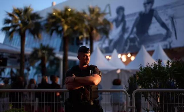 A police officer stands long the road near the red carpet during the 79th international film festival, Cannes, southern France, Wednesday, May 13, 2026. (AP Photo/John Locher)