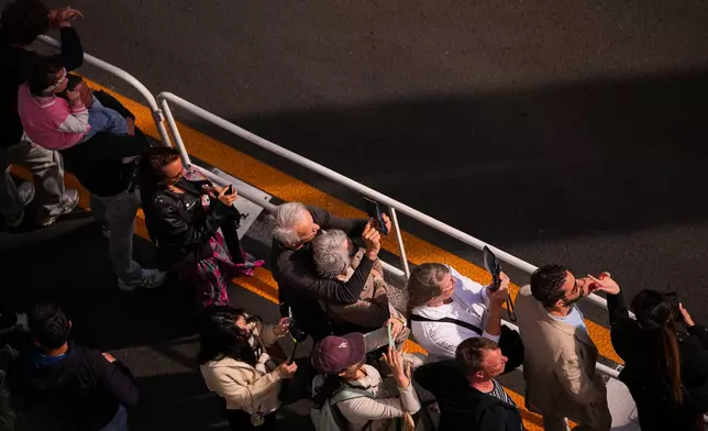 People line the street to catch a glimpse of the actors walking on red carpet during the 79th international film festival, Cannes, southern France, Thursday, May 14, 2026. (AP Photo/Andreea Alexandru)