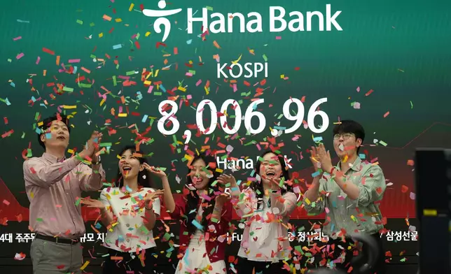 Employees of Hana Bank celebrate in a photo-op to mark the Korea Composite Stock Price Index (KOSPI) of over 8,000 points at a dealing room of Hana Bank in Seoul, South Korea, Friday, May 15, 2026. (AP Photo/Lee Jin-man)